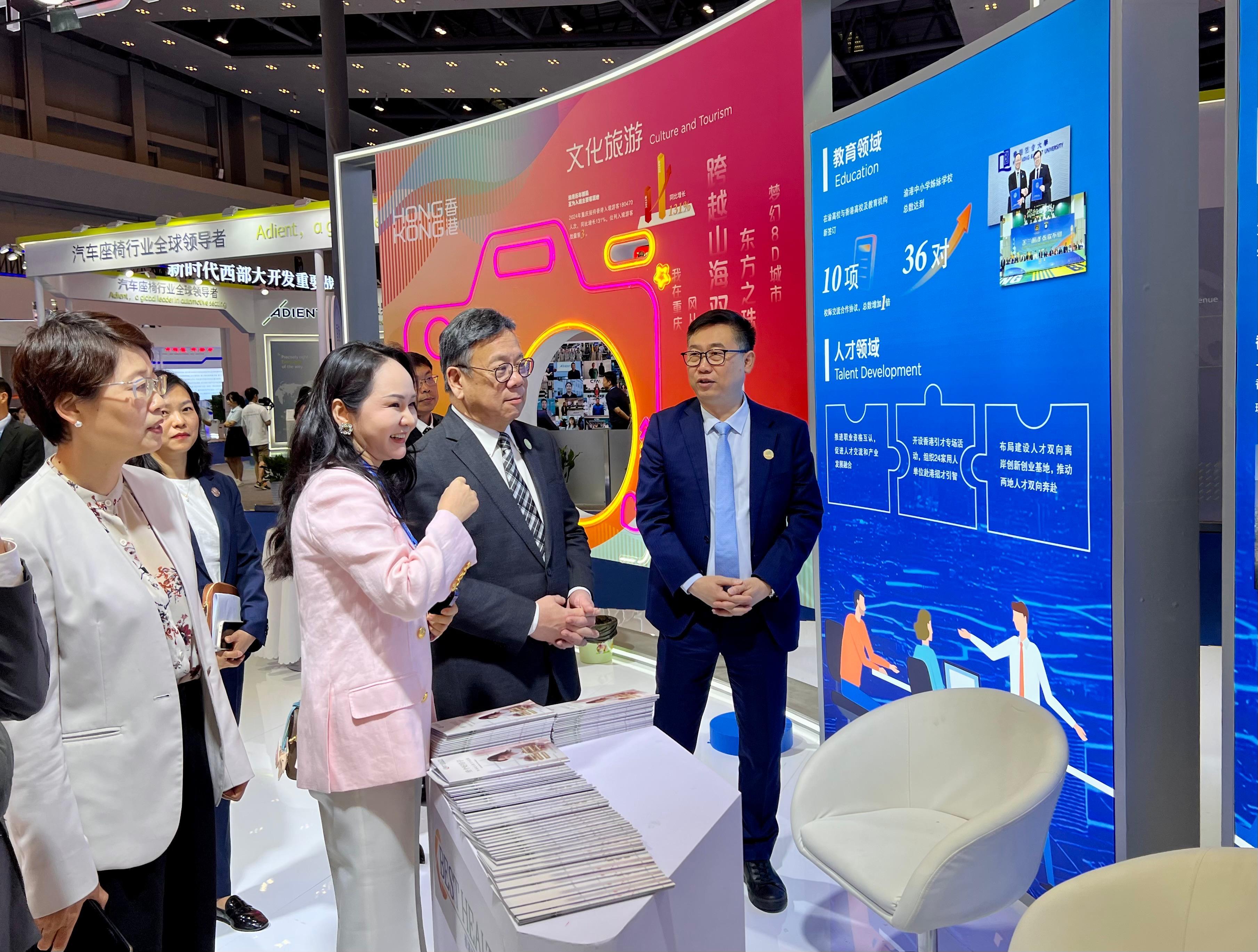 The Secretary for Commerce and Economic Development, Mr Algernon Yau, attended the Seventh Western China International Fair for Investment and Trade in Chongqing today (May 22). A Hong Kong Pavilion is set up at the fair to promote Hong Kong's strengths and showcase its role as an effective and premium trade and business platform for Mainland enterprises to go global. Photo shows Mr Yau (second right) touring the Hong Kong Pavilion to learn about the achievements of the co-operation between Hong Kong and Chongqing in various areas.